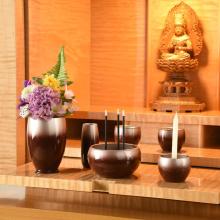 Japanese-made stainless steel Buddhist altar set in reddish purple. Includes a vase, flower vase, candle holder, incense burner, rice bowl, teacup, and incense holder. 
